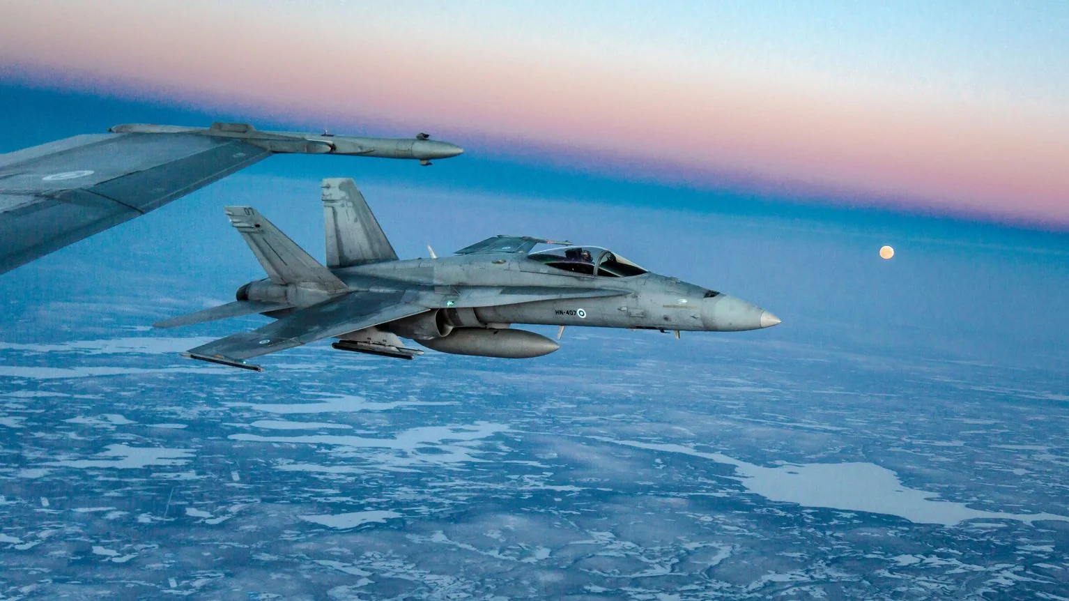 Фінський винищувач F/A-18 патрулює небо над засніженою місцевістю в пошуку дронів