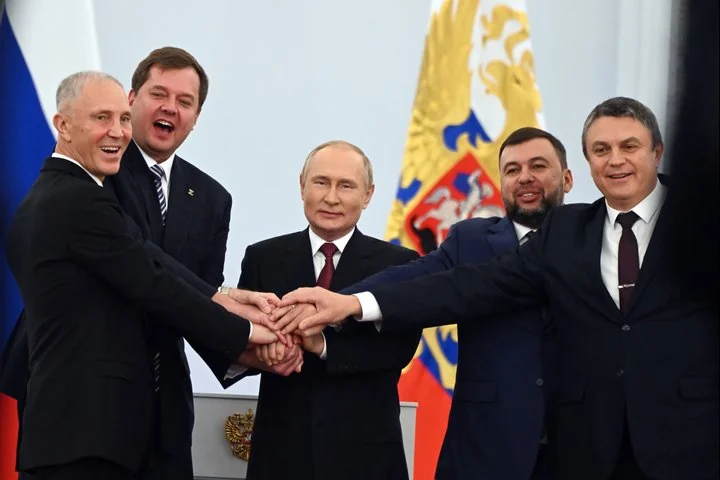Володимир Путін тисне руки з командуванням РФ на тлі прапорів Росії
