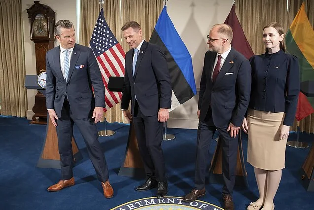 Міністр Латвії Байба Бразе з дипломатами США та Литви перед прапорами країн