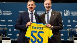 Андреа Мальдера та представник УАФ тримають памятну футболку з прізвищем тренера