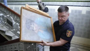 Поліцейський евакуює картину з Харківського художнього музею після удару дрона