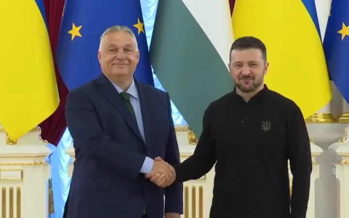 Віктор Орбан і Володимир Зеленський тиснуть руки на тлі прапорів Угорщини та ЄС