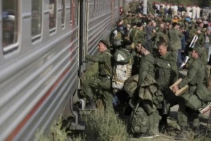 Російські солдати з речами сідають у потяг під час мобілізації