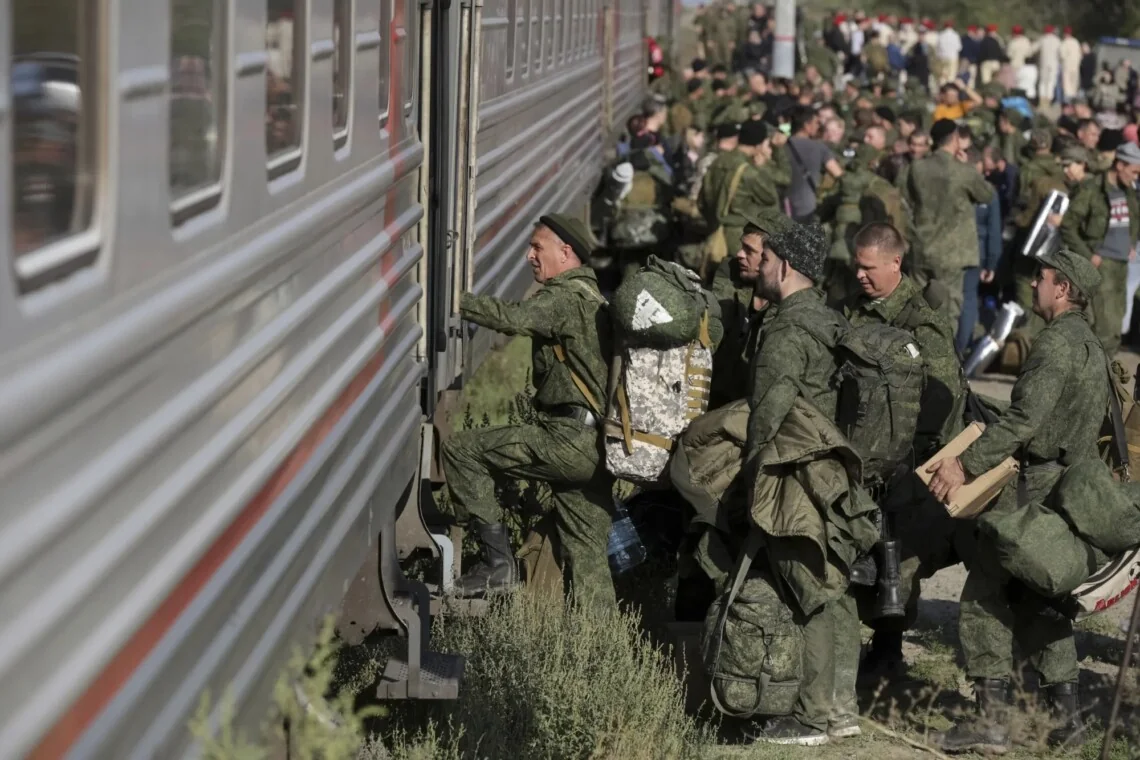 Російські солдати з речами сідають у потяг під час мобілізації
