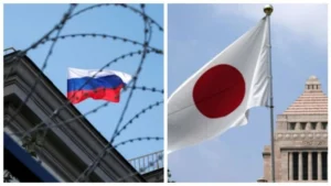 Флаг России за колючей проволокой рядом с флагом Японии возле здания