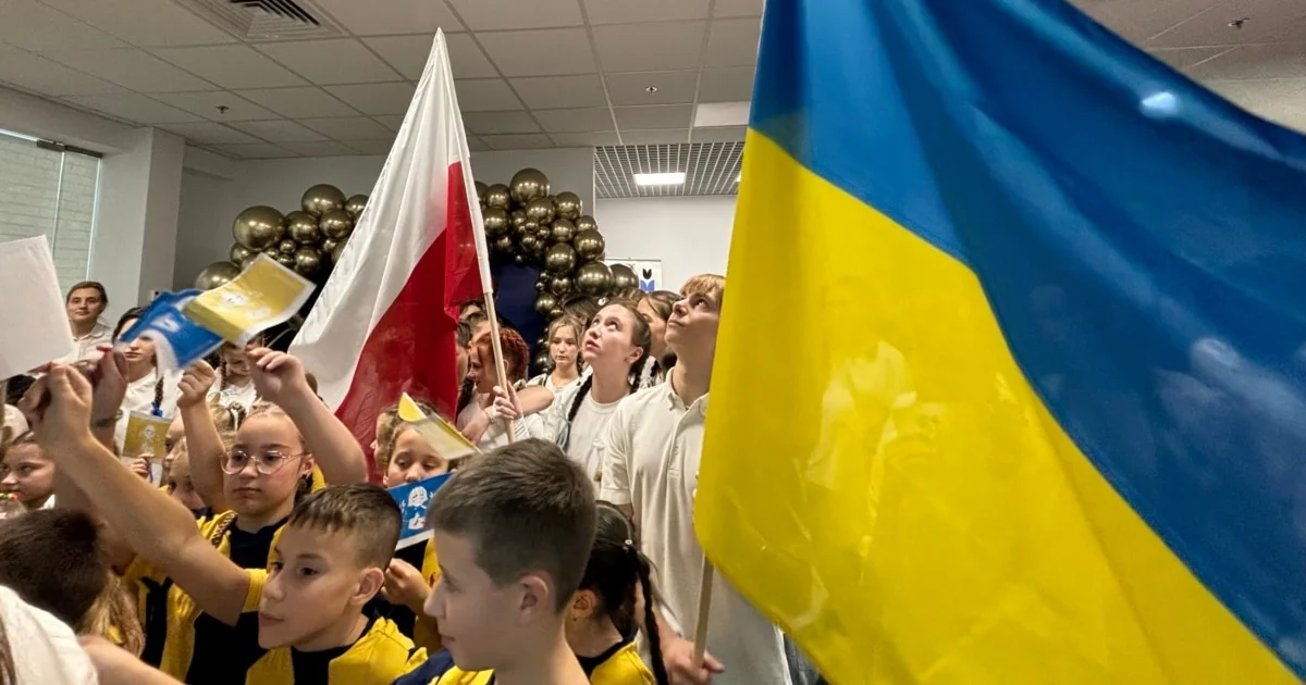 Українські школярі в Польщі з прапорами України та Польщі на заході