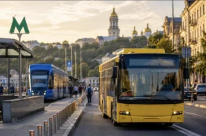 Жовтий автобус і синій трамвай на зупинці громадського транспорту в Києві