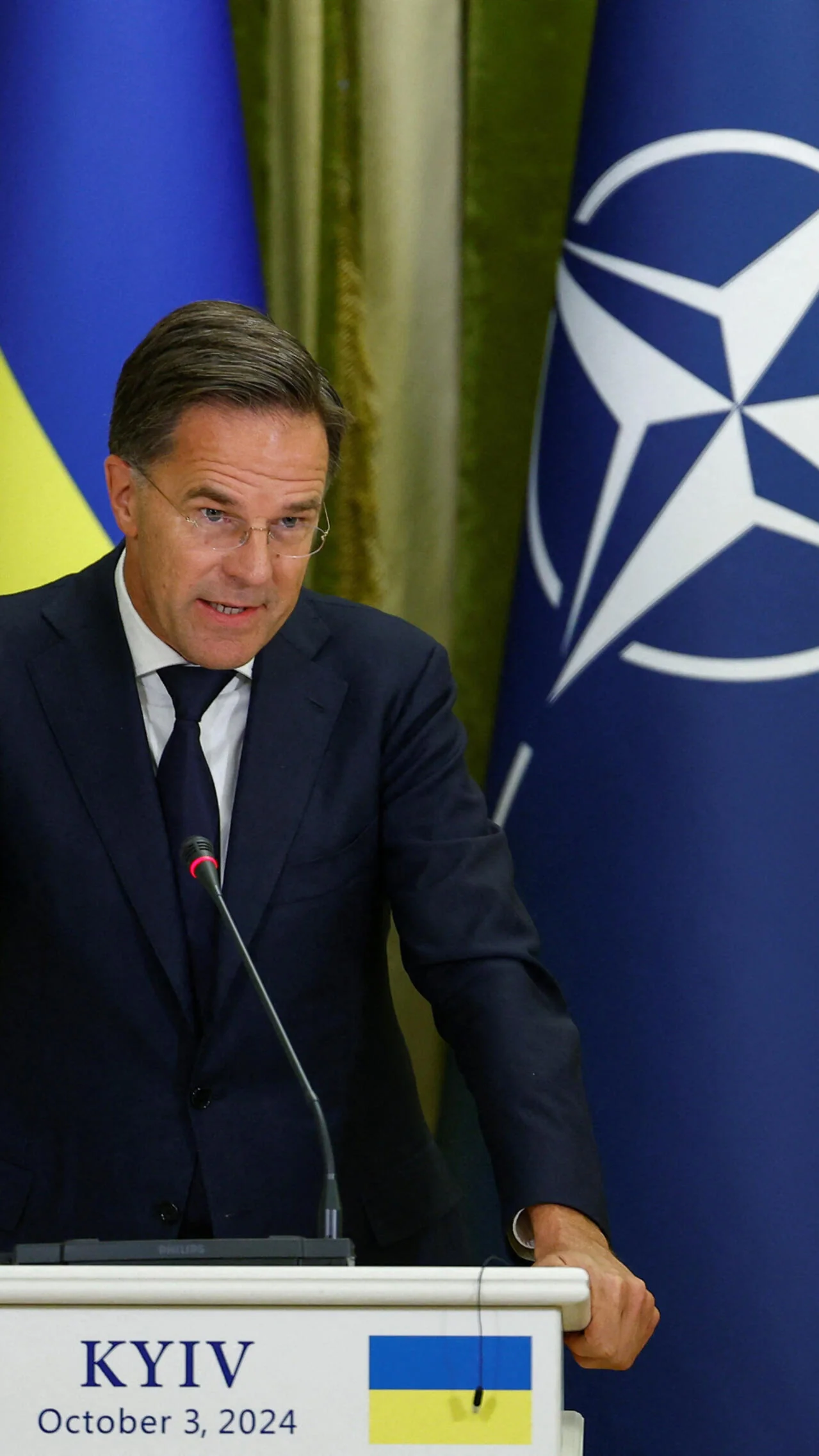 Марк Рютте на трибуні в Києві з прапорами України та НАТО