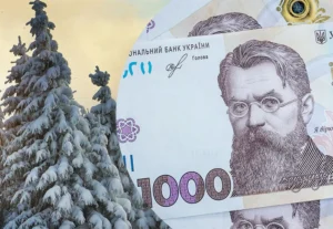 Банкнота 1000 гривен на фоне заснеженной ёлки для зимней помощи