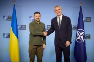 Зеленський і Столтенберг тиснуть руки на тлі прапорів України та НАТО