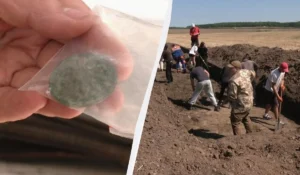 Рука тримає круглу бронзову бляху в пакеті, археологи копають траншею в полі